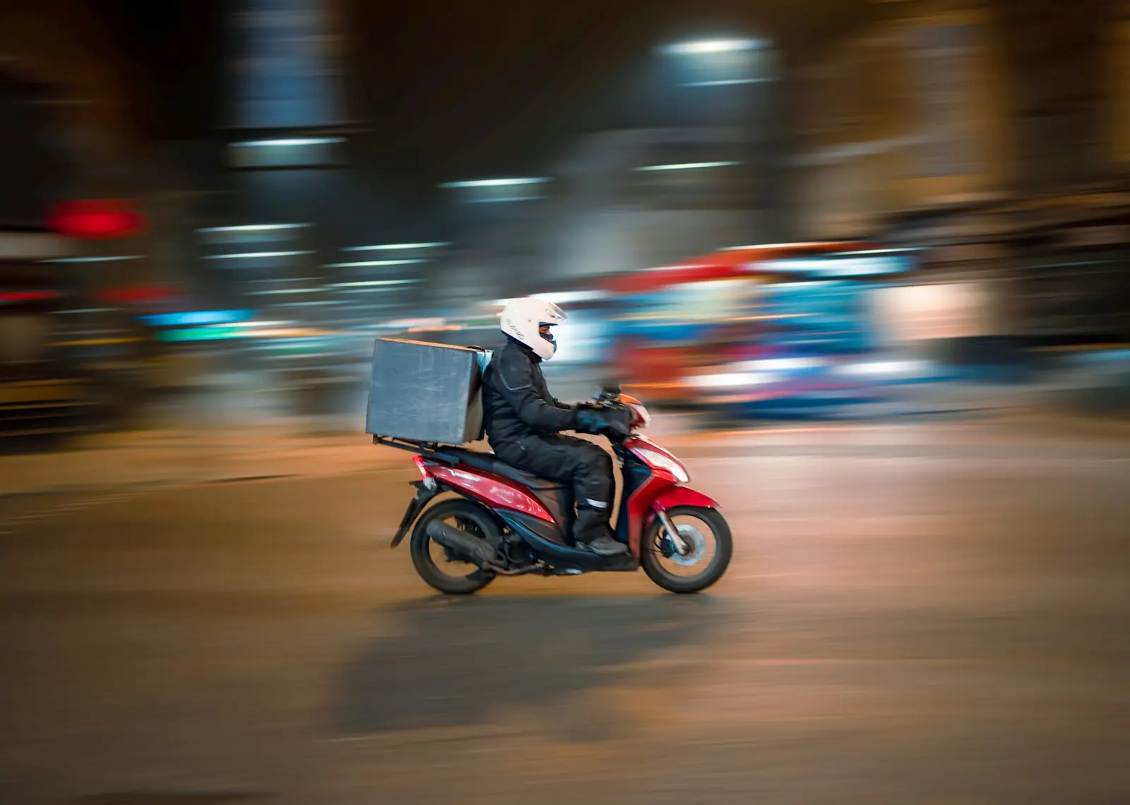 A courier on a scooter with a delivery box