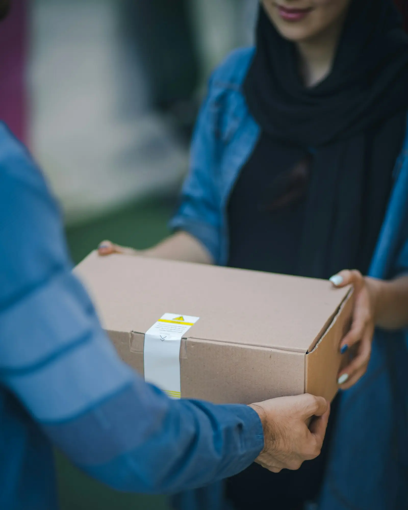 A sealed cardboard parcel being handed over
